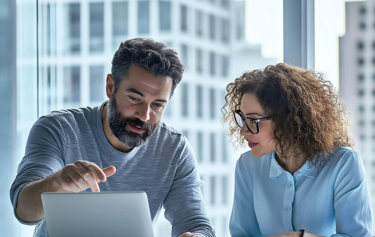 Zwei Entscheidungsträger besprechen in einem hellen Büro ein unternehmerisches Vorhaben am Computer